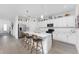 Modern kitchen with white cabinetry, stainless steel appliances, and a center island with bar seating at 8244 Shore Lake Dr, Englewood, FL 34224
