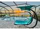 Lanai featuring a pool with chaise lounges, egg swing, and a sunset view of the lake at 8244 Shore Lake Dr, Englewood, FL 34224