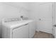 An organized laundry room with modern appliances, ample shelving, and tiled floors at 8244 Shore Lake Dr, Englewood, FL 34224