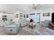Bright living room with wood-look flooring, ceiling fan, and a view of the pool at 8244 Shore Lake Dr, Englewood, FL 34224
