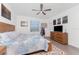 Spacious main bedroom with wood furnishings, fan, and decorative artwork at 8244 Shore Lake Dr, Englewood, FL 34224