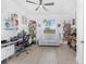 Office features a large window, ceiling fan, desk, sofa, and multiple bookshelves at 8244 Shore Lake Dr, Englewood, FL 34224