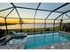 Screened in pool overlooking lake, perfect for relaxing evenings and enjoying beautiful sunset views at 8244 Shore Lake Dr, Englewood, FL 34224
