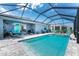 Inviting screened-in pool area with a comfortable seating, a lounge chair, and lush green backyard at 8244 Shore Lake Dr, Englewood, FL 34224