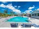 A refreshing community pool with ample seating under sunny blue skies at 8244 Shore Lake Dr, Englewood, FL 34224