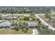 Aerial view of a residential home with a well-maintained lawn, tropical landscaping, and neighborhood at 857 Palmetto St, Englewood, FL 34223