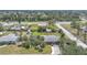 Aerial view of a residential home with a well-maintained lawn, tropical landscaping, and neighborhood at 857 Palmetto St, Englewood, FL 34223