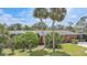 Lush backyard with a light-colored single-story home with light latticework details and tropical landscaping at 857 Palmetto St, Englewood, FL 34223