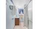 Small bathroom with blue walls, white tile flooring, shower, vanity, and blue curtains for the window at 857 Palmetto St, Englewood, FL 34223