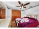 Bedroom with a sunflower themed comforter, a ceiling fan, closet, and wood floors at 857 Palmetto St, Englewood, FL 34223
