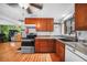 Efficient kitchen with wood cabinets, hardwood floors, and stainless-steel stove at 857 Palmetto St, Englewood, FL 34223