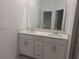 Bright bathroom features double sinks and vanities, large mirrors, and sleek fixtures at 8661 Seasalt Loop, Englewood, FL 34224