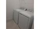 Laundry room featuring a matching washer and dryer set with a wire shelf above at 8661 Seasalt Loop, Englewood, FL 34224