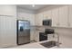 Bright kitchen features stainless steel appliances, white cabinets, and durable solid surface countertops at 8673 Seasalt Loop, Englewood, FL 34224