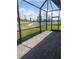 Covered screened patio with brick pavers overlooks backyard pond and landscape at 8673 Seasalt Loop, Englewood, FL 34224