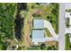 Aerial view of a home, garage, and driveway, complimented by lush green surroundings, a tranquil pond and a paved street at 868 Harvard St, Englewood, FL 34223