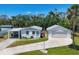 An updated white home with a long driveway, covered car port and two-car garage on a lush lawn at 868 Harvard St, Englewood, FL 34223