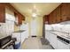 Cozy kitchen featuring wood cabinets, white appliances, and neutral countertops at 868 Harvard St, Englewood, FL 34223
