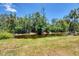 Scenic view of a backyard pond surrounded by lush vegetation and mature trees, creating a private oasis at 868 Harvard St, Englewood, FL 34223