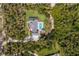 A bird's eye view of a home, pool, outdoor kitchen, and backyard bordered by a dense, green forest creating a private retreat at 9144 Spring Valley Rd, Englewood, FL 34224
