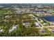 Overhead aerial view of a tree-lined estate that features a large home, pool, and lush landscaping at 9144 Spring Valley Rd, Englewood, FL 34224