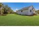 The spacious backyard is complete with a well-maintained lawn, lush landscaping, and a charming home exterior at 9144 Spring Valley Rd, Englewood, FL 34224