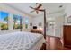 Spacious bedroom features a four-poster bed, hardwood floors and backyard views at 9144 Spring Valley Rd, Englewood, FL 34224