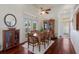 Charming dining room with hardwood floors, natural light, and glass enclosed display case at 9144 Spring Valley Rd, Englewood, FL 34224