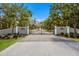 View of the entrance gate to a private community, featuring decorative pillars and a manicured lawn at 9144 Spring Valley Rd, Englewood, FL 34224