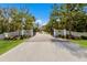 Grand entrance to Heritage Oaks, featuring a gated driveway lined with lush landscaping and a serene atmosphere at 9144 Spring Valley Rd, Englewood, FL 34224