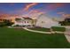 Stunning two-story home featuring a welcoming porch, manicured lawn, and lush landscaping, bathed in the warm glow of sunset at 9144 Spring Valley Rd, Englewood, FL 34224