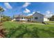 Beautiful white two-story home with a well-manicured lawn and a charming wraparound porch at 9144 Spring Valley Rd, Englewood, FL 34224