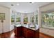 Bright eat-in kitchen with bay windows, central island, hardwood floors, and natural light at 9144 Spring Valley Rd, Englewood, FL 34224