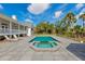 Exterior daytime image of the fenced pool and spa area with patio furniture, adjacent to a covered outdoor porch at 9144 Spring Valley Rd, Englewood, FL 34224