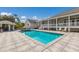 An exterior daytime shot of a pool, spa, and poolside bar area with patio furniture and covered porch at 9144 Spring Valley Rd, Englewood, FL 34224