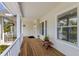 Charming porch with wood flooring, white railings, and views of surrounding trees and greenery at 9144 Spring Valley Rd, Englewood, FL 34224