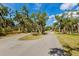 The wide street surrounded by a canopy of mature trees offers a scenic drive through the community at 9144 Spring Valley Rd, Englewood, FL 34224