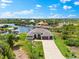 Aerial view of a beautiful home with a long driveway, three-car garage, and waterfront access at 9470 Wacker Ter, Port Charlotte, FL 33981