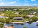 Stunning waterfront property featuring a screened pool, boat dock, and lush landscaping at 9470 Wacker Ter, Port Charlotte, FL 33981