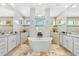 Luxurious bathroom featuring dual vanities, travertine floors, soaker tub and abundant natural light at 9470 Wacker Ter, Port Charlotte, FL 33981