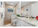 Bright bathroom featuring tiled shower, granite vanity, and ample natural light to create a soothing and spa-like atmosphere at 9470 Wacker Ter, Port Charlotte, FL 33981