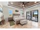 Well-appointed bedroom with fan, travertine floors, and access to the outdoor kitchen and pool at 9470 Wacker Ter, Port Charlotte, FL 33981