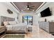 Primary bedroom with tray ceiling, plantation shutters, tv, and travertine flooring at 9470 Wacker Ter, Port Charlotte, FL 33981