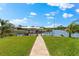 Lush landscaping leads to a private boat dock with a covered lift on a wide canal at 9470 Wacker Ter, Port Charlotte, FL 33981