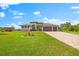 Beautiful home with a three-car garage, well-manicured lawn, and a paved driveway at 9470 Wacker Ter, Port Charlotte, FL 33981