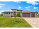 Beautiful single Gathering home with a three car garage, well manicured lawn, and upgraded paver driveway at 9470 Wacker Ter, Port Charlotte, FL 33981