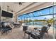 Spacious covered patio features comfortable seating, a summer kitchen, and tranquil views of the pool and the lake at 9470 Wacker Ter, Port Charlotte, FL 33981