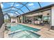 An expansive pool with an integrated spa, a screen enclosure, and a seamless flow to the interior through sliding glass doors at 9470 Wacker Ter, Port Charlotte, FL 33981