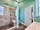 Bathroom shower featuring pebbled floor, shower seat, tiled walls, and glass doors at 9594 Doubloon Trl, Placida, FL 33946