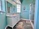 Bathroom featuring double sinks, vanity, walk-in shower, tile flooring, and blue walls at 9594 Doubloon Trl, Placida, FL 33946